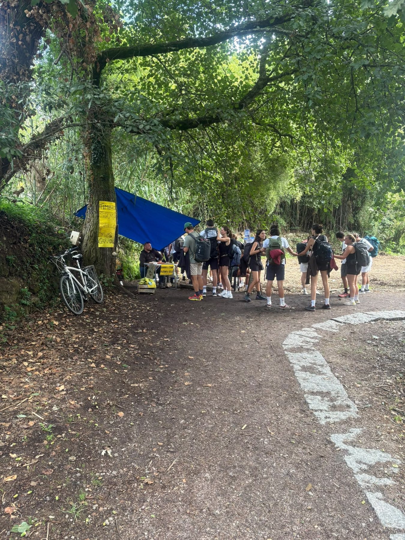 Pilgrims gathered beside the banana and stamp point on the Camino