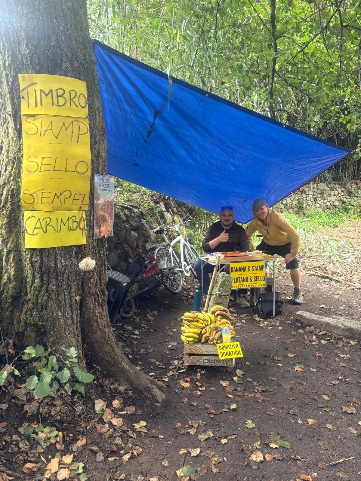 A welcoming moment at the Camino stamp table beside the banana stand
